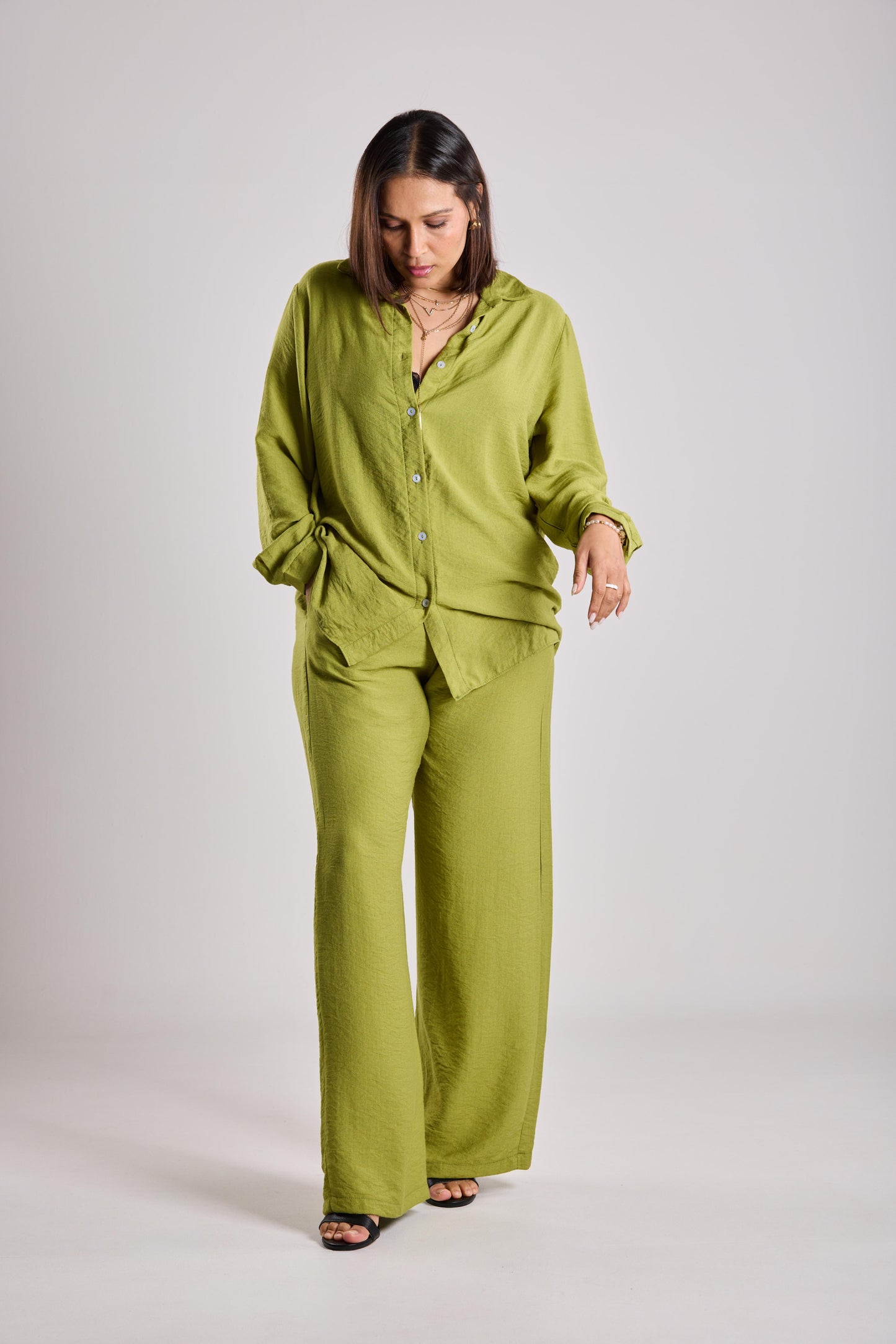 Woman wearing a green two-piece on a plain background
