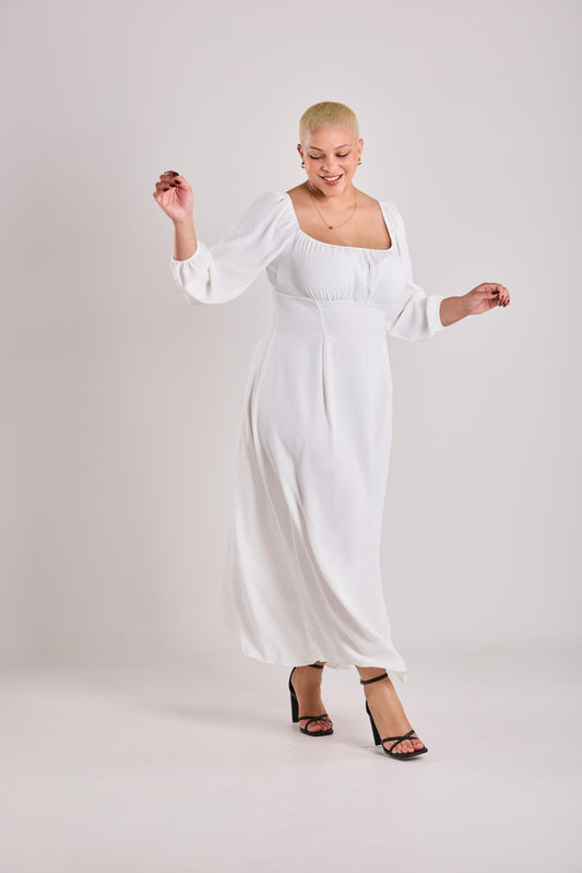Woman wearing a white A line Maxi Dress against a plain background