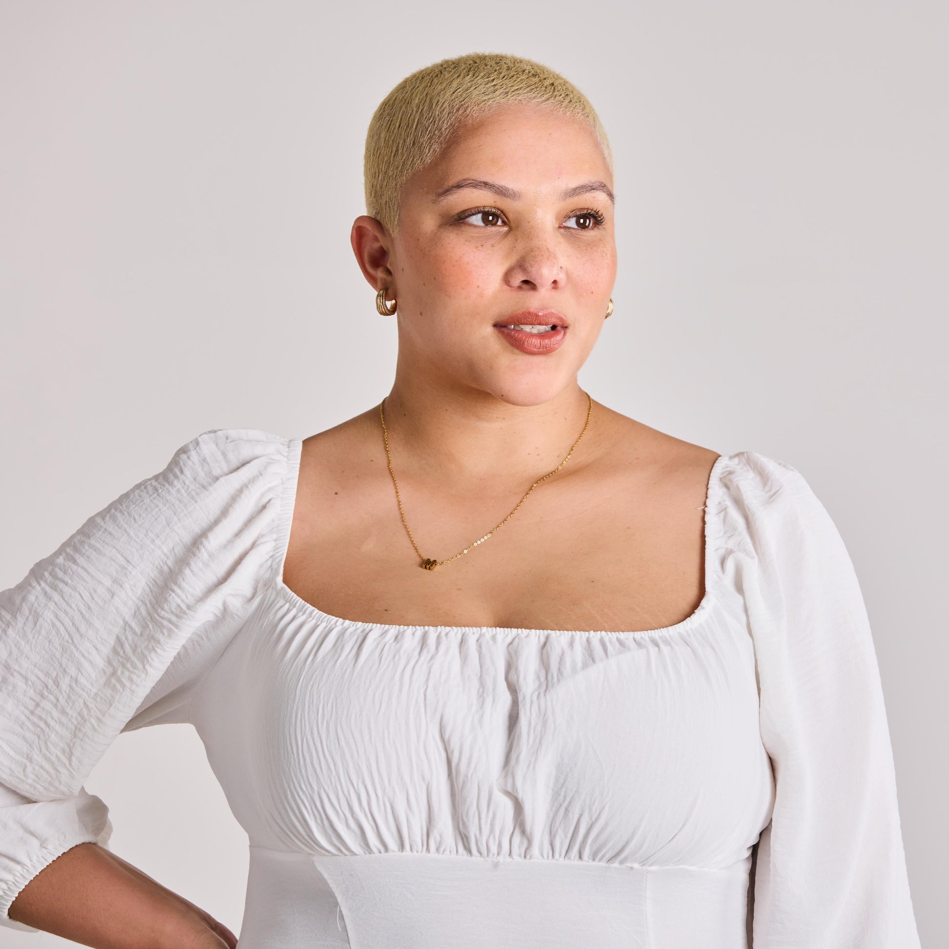 Woman wearing a white A line Maxi Dress against a plain background